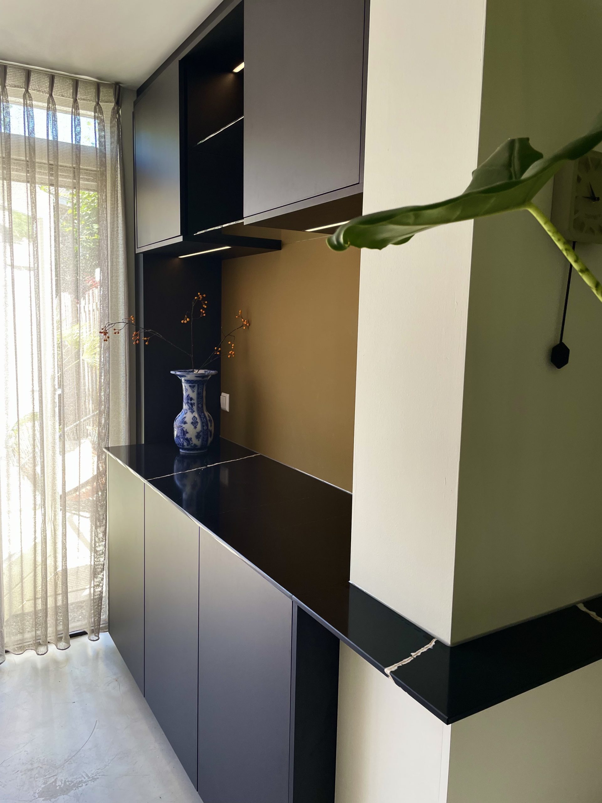 Schuine detailfoto van luxe servieskast met glazen schappen